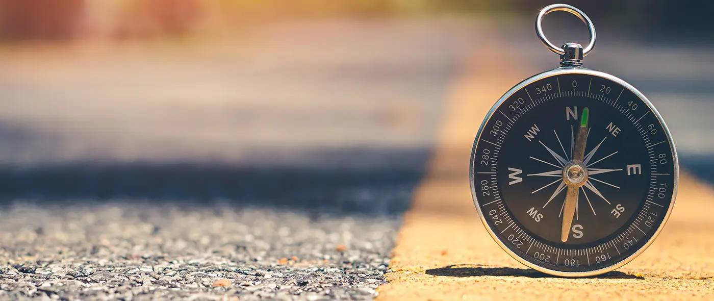 A compass on the road pointing North to show direction