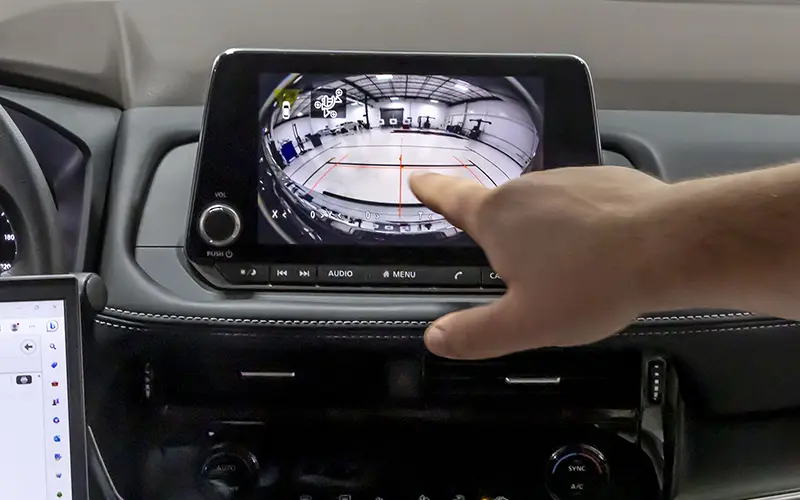 Technician testing vehicle sensors for proper ADAS calibration to ensure systems function properly after collision repair